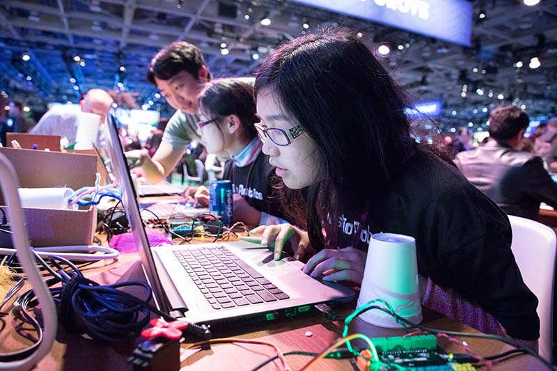 Young adults learn tech skills at Dreamforce, with support from volunteers.