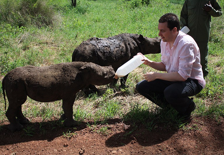 Thijs volunteers in Kenya, feeding a baby rhino