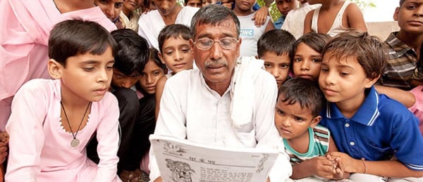 Man reading newspaper with kids