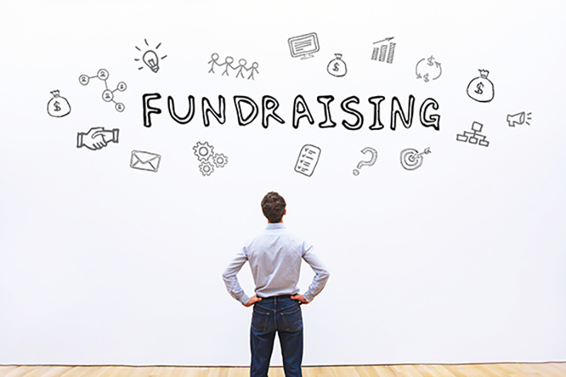 Man facing a wall with fundraising graphic