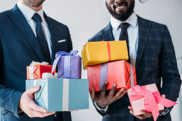 Businessmen holding wrapped gifts
