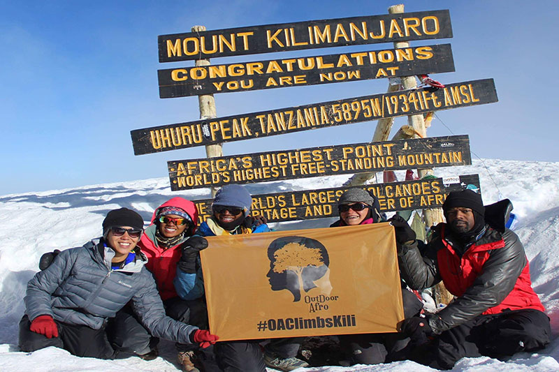 People posing on top of Mount Kilimanjaro