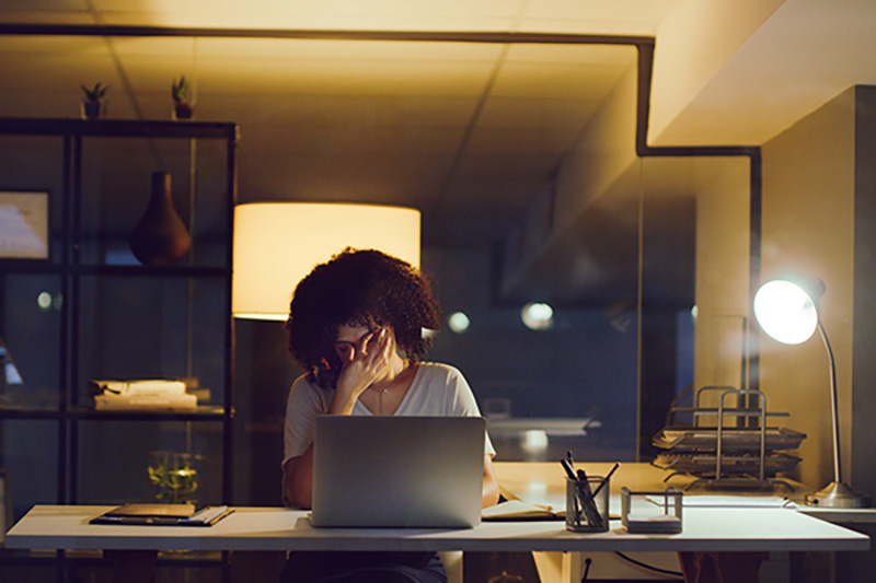 Person working late at a desk looking tired