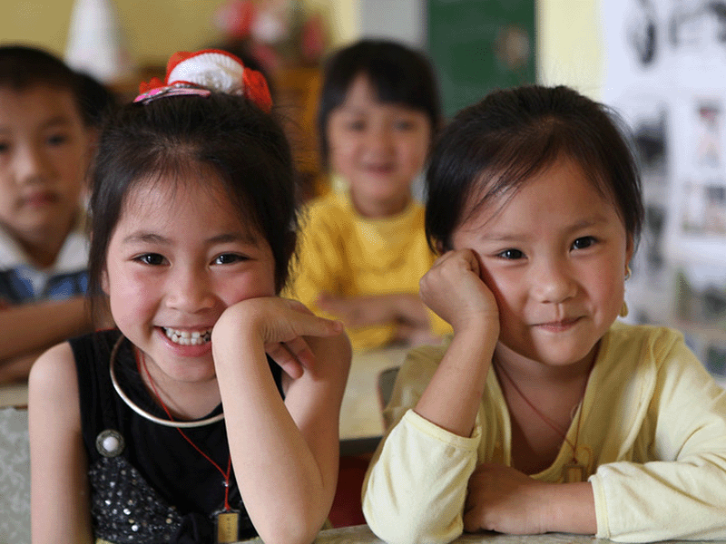 Young children sitting in a classroom.